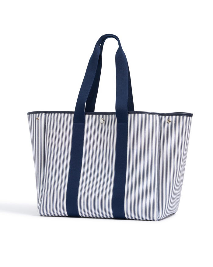 The Beckett Canvas Tote Bag in Navy French Ticking features bold vertical blue and white stripes with solid navy handles and trim, displayed upright on a white background.