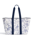 The Beckett Canvas Tote Bag in Timeless Toile, featuring a blue floral print and navy blue handles and trim, stands upright on a white background.