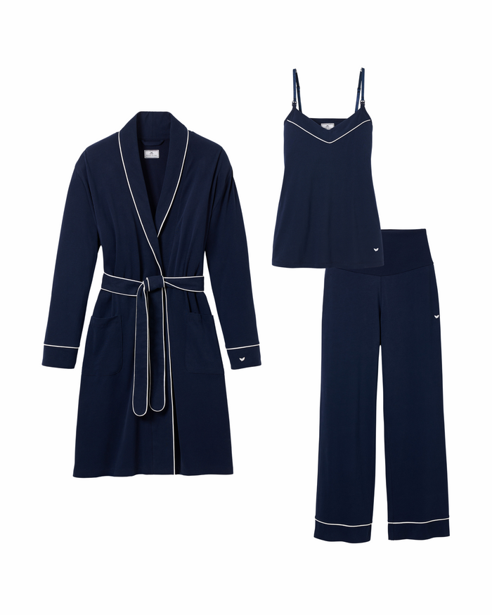 Enjoy luxurious relaxation with Petite Plumes The Cozy Maternity Set in Navy. This set features a robe with a tie belt, sleeveless top, and pants, all in navy blue with white piping and logo details. Elegantly packaged in a gift box for the perfect touch.