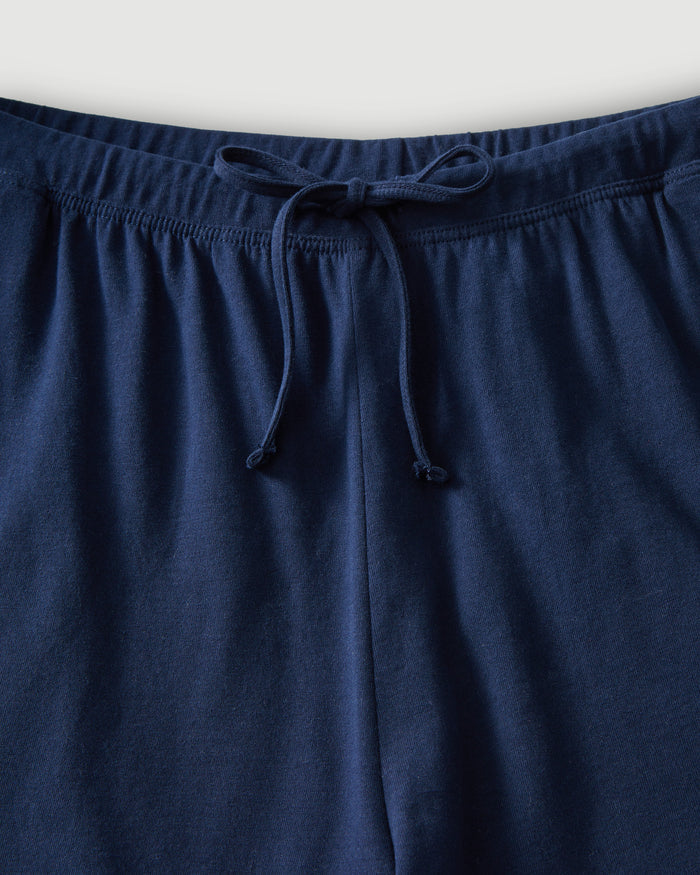 The Olivia Pima Short Set in Navy features a short-sleeve button-up top with a chest pocket and matching drawstring shorts, both displayed flat on a white background.