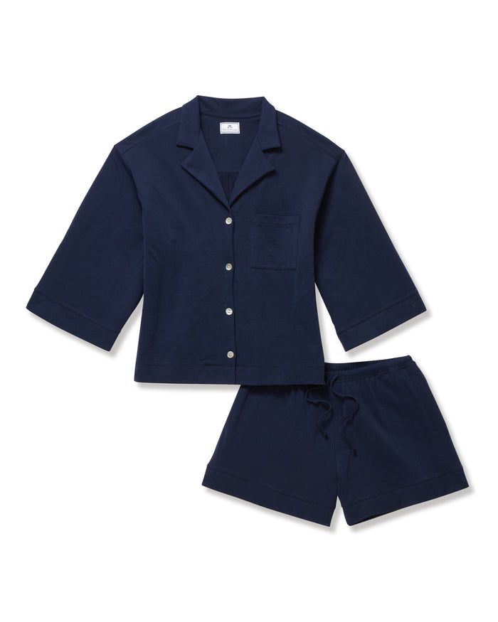 The Olivia Pima Short Set in Navy features a short-sleeve button-up top with a chest pocket and matching drawstring shorts, both displayed flat on a white background.