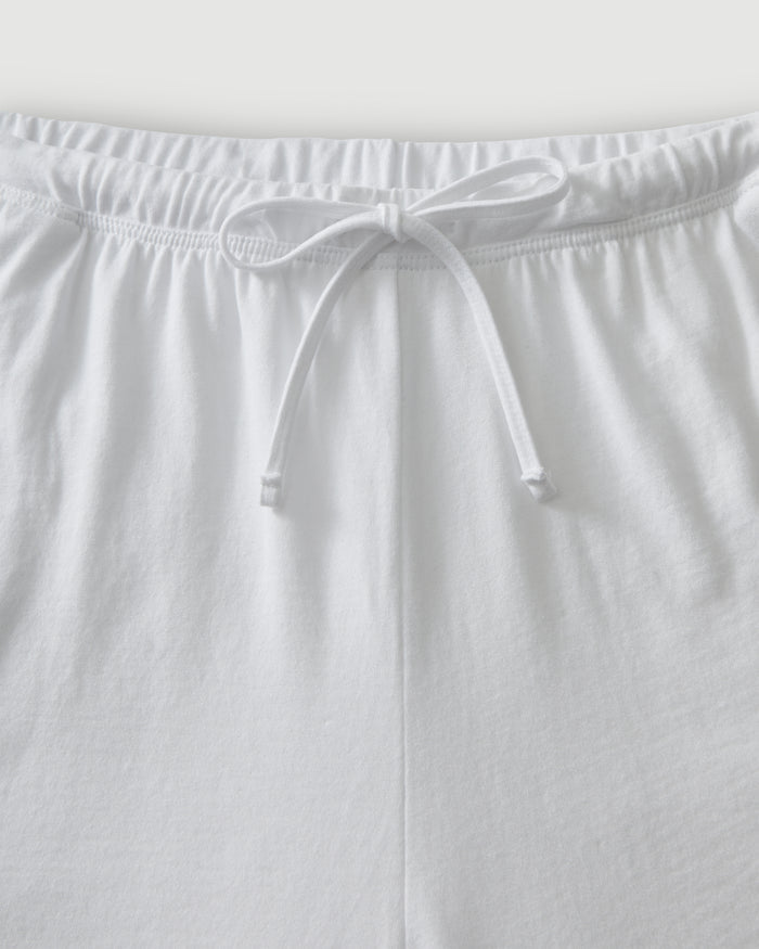 The Olivia Pima Short Set in White features a matching pajama set with a button-up, collared shirt with a chest pocket and three-quarter sleeves, paired with elastic waist drawstring shorts.