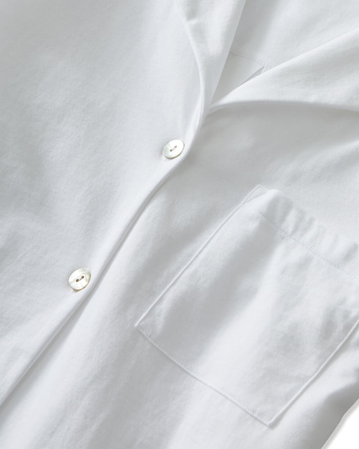 The Olivia Pima Short Set in White features a matching pajama set with a button-up, collared shirt with a chest pocket and three-quarter sleeves, paired with elastic waist drawstring shorts.