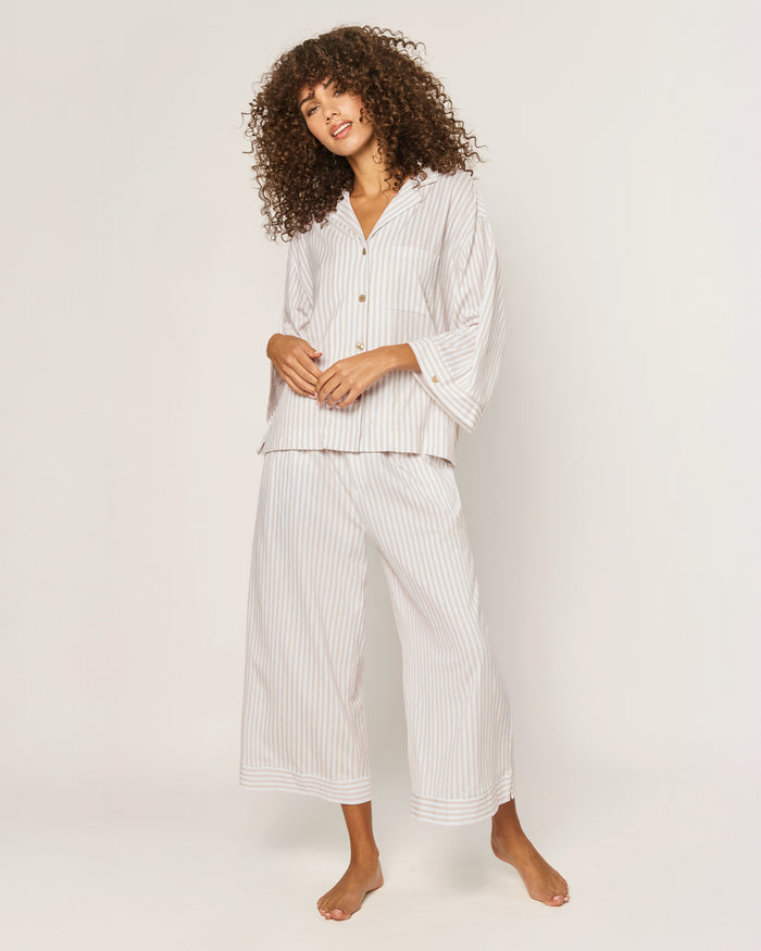 The Olivia Wide Leg Pima Pajama Set in Camel Ticking features light-colored, long-sleeve striped pajamas with brown buttons and matching drawstring pants, displayed flat on a white background.