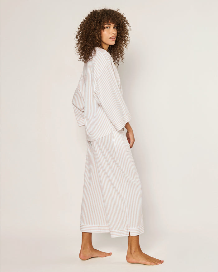 The Olivia Wide Leg Pima Pajama Set in Camel Ticking features light-colored, long-sleeve striped pajamas with brown buttons and matching drawstring pants, displayed flat on a white background.