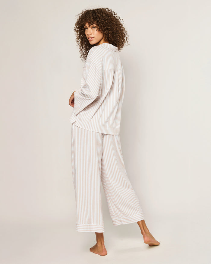 The Olivia Wide Leg Pima Pajama Set in Camel Ticking features light-colored, long-sleeve striped pajamas with brown buttons and matching drawstring pants, displayed flat on a white background.