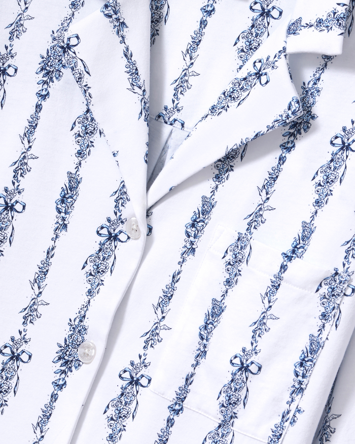 Close-up of The Olivia Wide Leg Pima Pajama Set in Navy Mayfair Toile, featuring a white shirt with blue floral and bow vertical stripe patterns, white buttons, and a visible front pocket.