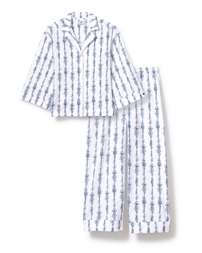 The Olivia Wide Leg Pima Pajama Set in Navy Mayfair Toile, featuring a long-sleeve collared button-up top and matching wide-leg pants with blue vertical floral stripes on a white background, is laid flat for display.