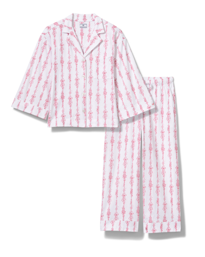 The Olivia Wide Leg Pima Pajama Set in Pink Mayfair Toile features a soft, lightweight fabric with long wide-leg pants and a button-up top. Both pieces are adorned with a vertical pattern of pink Mayfair toile floral designs, and the collared top has long sleeves for added comfort.