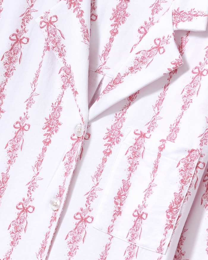 Close-up of the Olivia Wide Leg Pima Pajama Set in Pink Mayfair Toile, showcasing a white shirt with a pink floral and bow print, white buttons, and a front pocket.