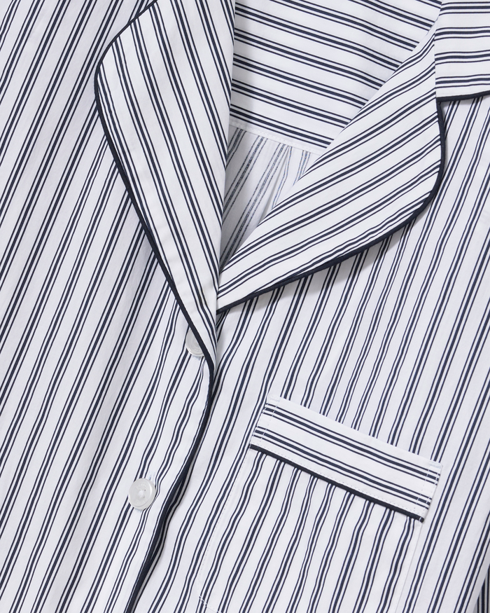 Close-up of The Celine Poplin Pajama Set in Navy French Ticking, featuring a white shirt with navy vertical stripes, showcasing the collar, buttons, and a chest pocket aligned with the striped pattern.