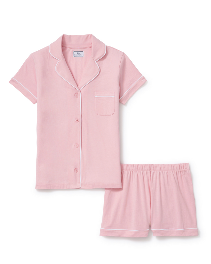 The Poppy Lightweight Pima Short Set in Pink, featuring a light pink short-sleeve pajama shirt with white piping and matching shorts, both laid flat on a white background.