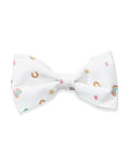 The Twill Dog Bow Tie in Good Luck Charms is a white bow tie adorned with small, colorful rainbows, horseshoes, hearts, and stars scattered across the fabric.