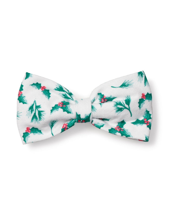 The Petite Plume Dog Bow Tie in Sprigs of the Season features a festive white fabric adorned with green holly leaves and red berries, perfect for holiday pet fashion.