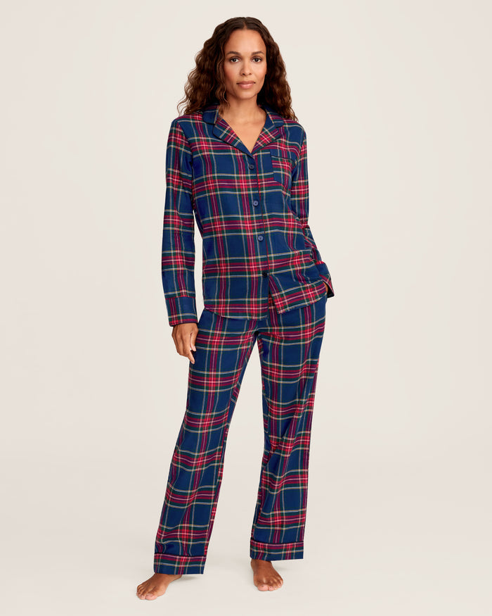 Close-up of Windsor Tartan fabric with red, green, and white stripes on navy by Petite Plume. The soft, brushed cotton texture resembles a classic pajama set with a button and lapel for added coziness.