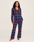 Close-up of Windsor Tartan fabric with red, green, and white stripes on navy by Petite Plume. The soft, brushed cotton texture resembles a classic pajama set with a button and lapel for added coziness.