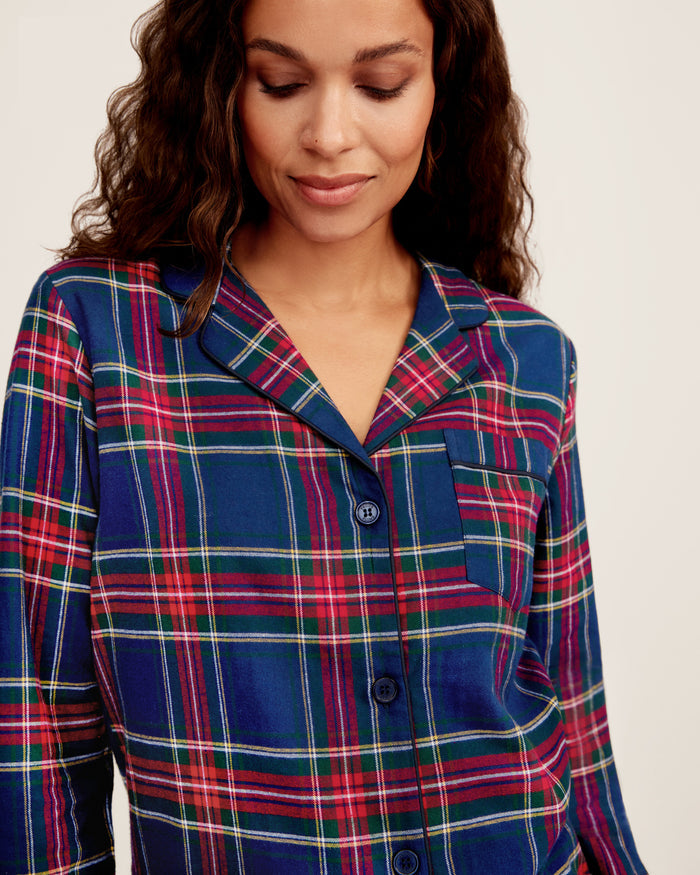 Close-up of Windsor Tartan fabric with red, green, and white stripes on navy by Petite Plume. The soft, brushed cotton texture resembles a classic pajama set with a button and lapel for added coziness.