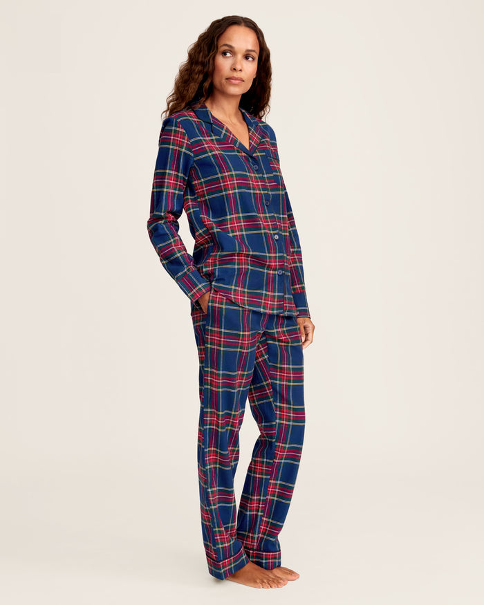 Close-up of Windsor Tartan fabric with red, green, and white stripes on navy by Petite Plume. The soft, brushed cotton texture resembles a classic pajama set with a button and lapel for added coziness.