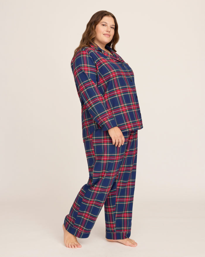 Close-up of Windsor Tartan fabric with red, green, and white stripes on navy by Petite Plume. The soft, brushed cotton texture resembles a classic pajama set with a button and lapel for added coziness.