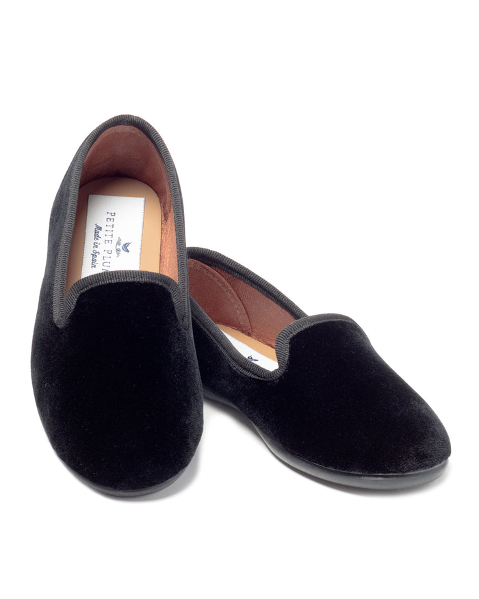 Petite Plumes Womens Hamptons Loafer in Black Velvet exhibits an elegant design with a subtle shine, accompanied by a visible label inside one shoe against a white background.
