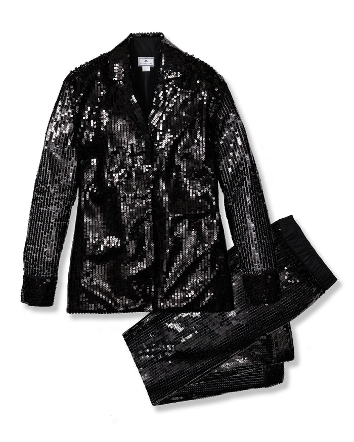 The Womens Pajama Set in Black Sequins by Petite Plume features a shimmering jacket with a notched lapel and coordinated pants. The tailored fit and pajama silhouette balance glamour and comfort for sophisticated style.