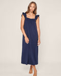 A woman wearing the Petite Plume Womens Pima Clara Nightgown in navy, showcasing its Peruvian Pima cotton fabric, stands barefoot against a neutral background. She has long brown hair and a relaxed posture, with her left hand gently resting on her hip.