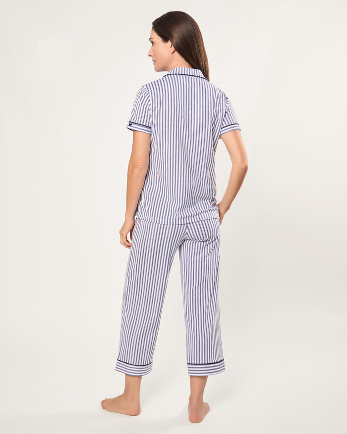 The Women's Pima Crop Pajama Set in Navy French Ticking features a blue and white vertical stripe design, short sleeves, a collared button-up top with chest pocket, and matching long pants.