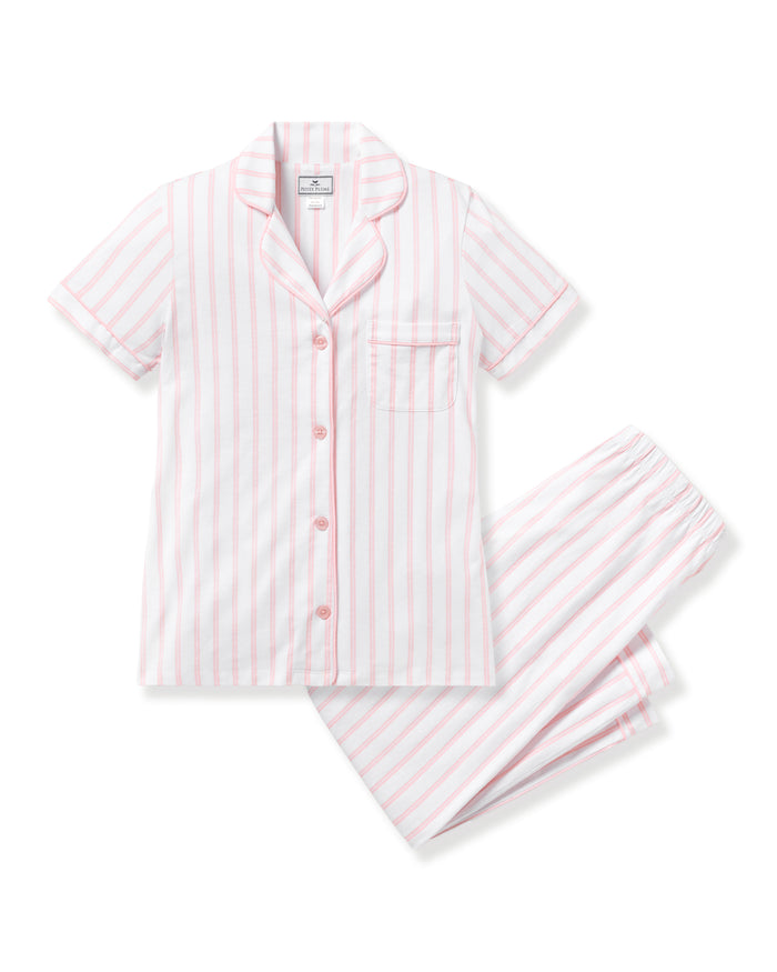 The Womens Pima Crop Set by Petite Plume, in pink and white stripe, features short-sleeved pajamas made from Peruvian Pima cotton. It includes a button-up shirt with a chest pocket and matching elastic waistband pants, displayed on a white background.