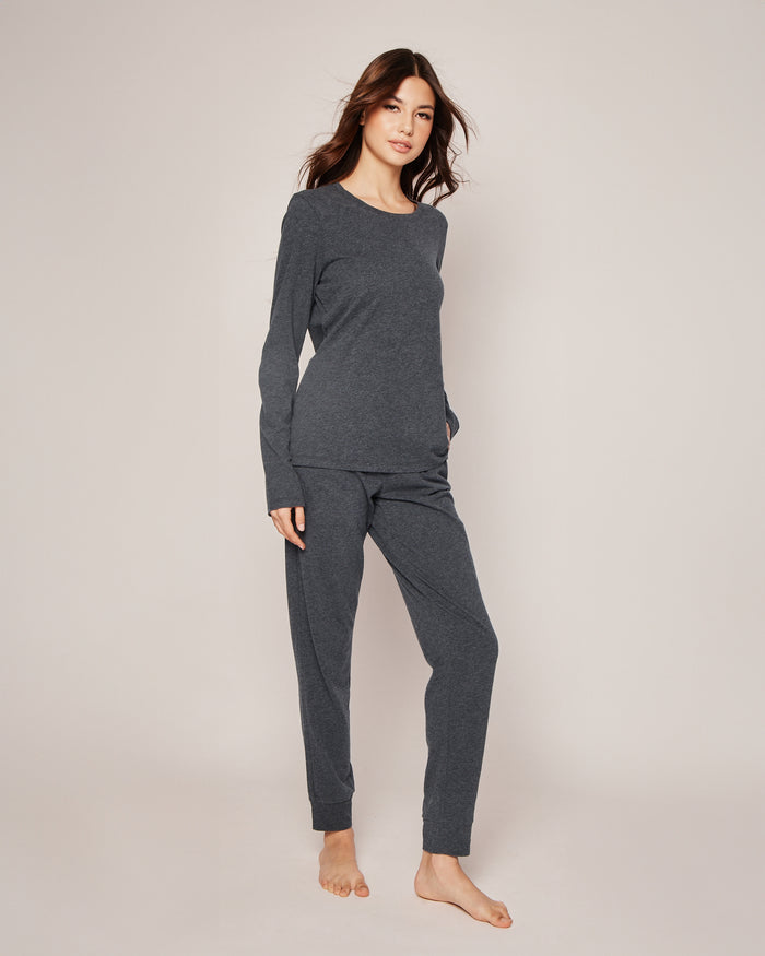 A person with long hair wears Petite Plumes Womens Pima Lounge Pants in Dark Heather Grey, made from 100% Peruvian Pima cotton. Barefoot on a neutral background, they exude elegance and comfort.