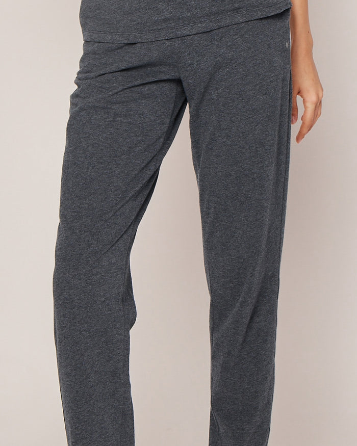 A person in Petite Plumes Womens Pima Lounge Pants in Dark Heather Grey stands against a light background, hand by their side. Only the lower body is visible, highlighting the elegance of our Pima Collection crafted from 100% Peruvian Pima cotton.