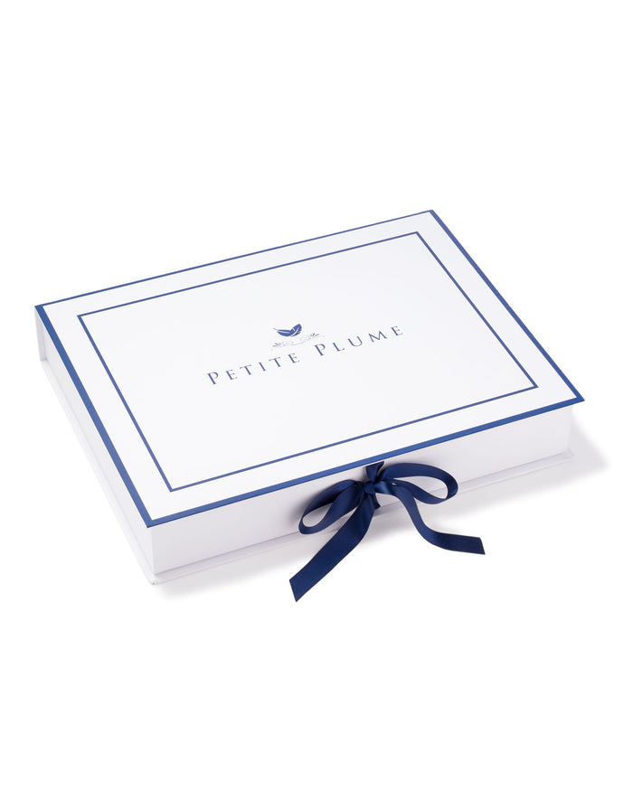 A white rectangular gift box features Petite Plume elegantly scripted in blue with a small bird logo. Tied with a chic dark blue ribbon, its reminiscent of the luxurious Womens Pima Maternity Camisole in Light Heather Grey by Petite Plume.