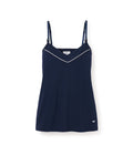 The Womens Pima Maternity Camisole in Navy by Petite Plume is sleeveless with thin adjustable straps, a V-neckline, subtle white trim, a small logo on the hem, and a convenient clipdown nursing function. The background is plain white.
