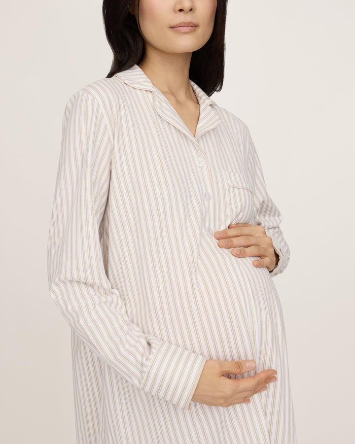 The Women's Pima Maternity Nightshirt in Camel Ticking features beige and white vertical stripes, long sleeves with cuffs, a collar, chest pocket, and partial button placket, and falls to knee length.