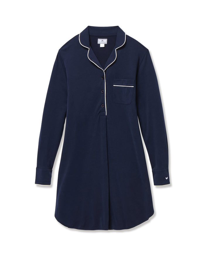 The Women's Pima Maternity Nightshirt in Navy features long sleeves, white piping on the collar, pocket, and cuffs, a chest pocket, button v-neckline, and a relaxed fit.