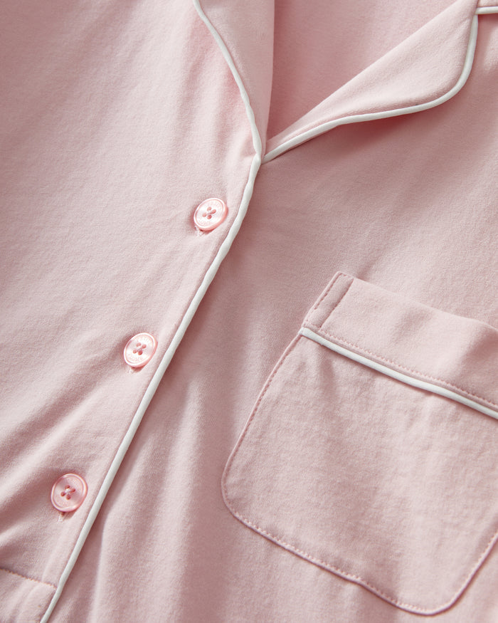 The Women's Pima Maternity Nightshirt in Pink features long sleeves, white piping, a collar, front buttons, single chest pocket, and a curved hem in soft, comfortable fabric.