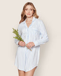 A woman wears the Petite Plume Womens Pima Nightshirt in Periwinkle and White Stripe, made from soft Peruvian Pima cotton jersey knit. She holds a green branch and stands against a plain light background, looking at the camera neutrally.