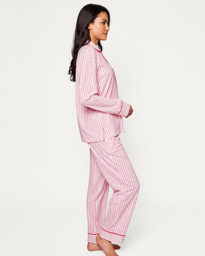 Close-up of Petite Plumes Womens Pima Pajama Set in Antique Red Ticking, showcasing luxury fabric with red and white vertical stripes. The image reveals part of the garment with a white button, collar, and pocket trimmed in red, hinting at its soft and cozy Peruvian Pima cotton.