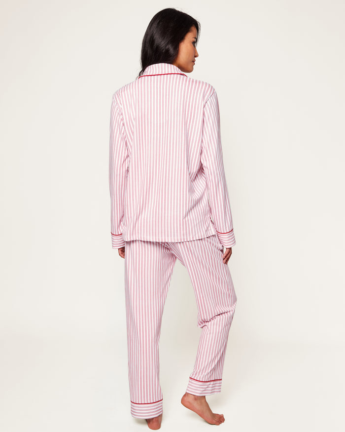 Close-up of Petite Plumes Womens Pima Pajama Set in Antique Red Ticking, showcasing luxury fabric with red and white vertical stripes. The image reveals part of the garment with a white button, collar, and pocket trimmed in red, hinting at its soft and cozy Peruvian Pima cotton.