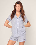 A woman with long brown hair confidently poses in the Womens Pima Pajama Short Set by Petite Plume, featuring a blue and white striped, short-sleeve top and matching shorts, made from 100% cotton twill inspired by a French ticking design.