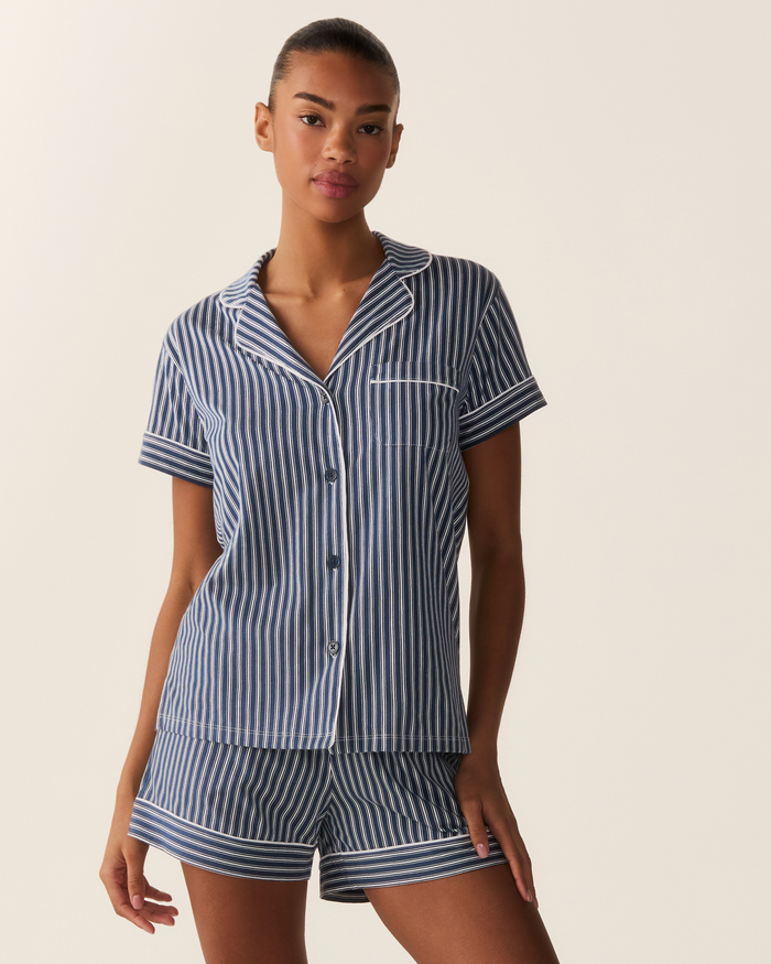 Wearing the Women’s Pima Short Sleeve Short Set in Admiral Ticking, a person stands against a plain light background.