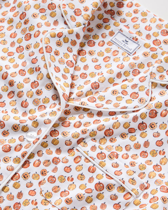 The Women's Pima Short Sleeve Short Set in Pumpkin Patch features a collared button-up top and matching shorts, both white with an orange and red fruit print and white piping on the edges.
