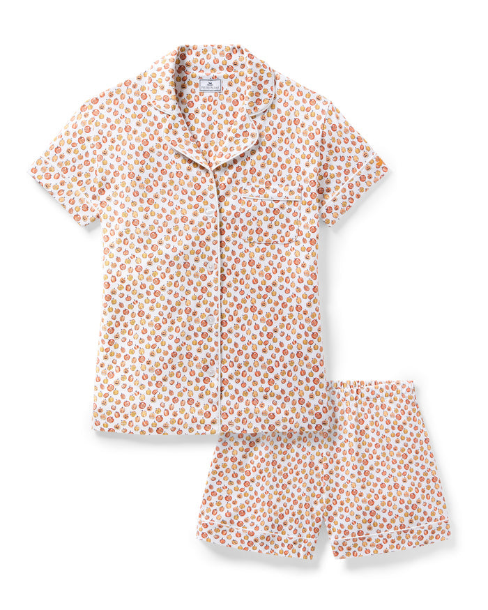 The Women's Pima Short Sleeve Short Set in Pumpkin Patch features a collared button-up top and matching shorts, both white with an orange and red fruit print and white piping on the edges.