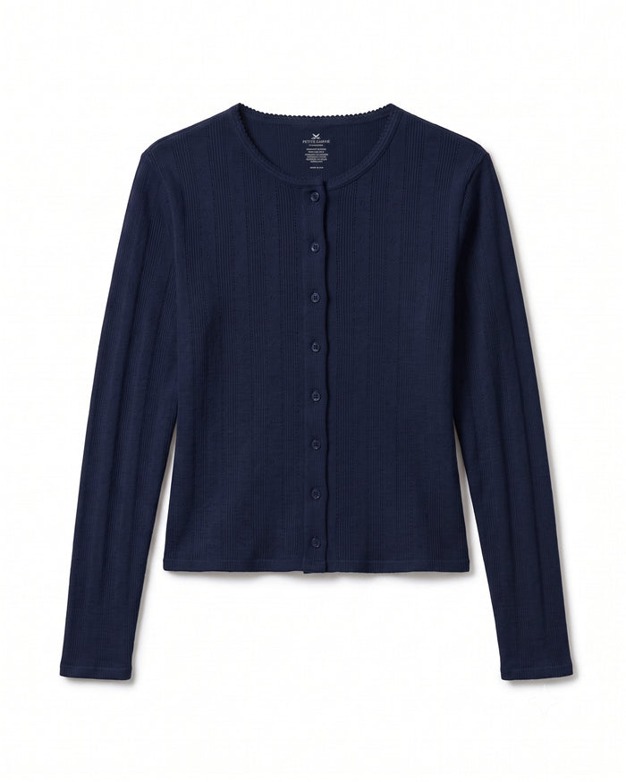 The Women’s Pointelle Cardigan in Navy is a long-sleeve, ribbed cardigan featuring a round neckline and button-down front, displayed laid flat on a white background.