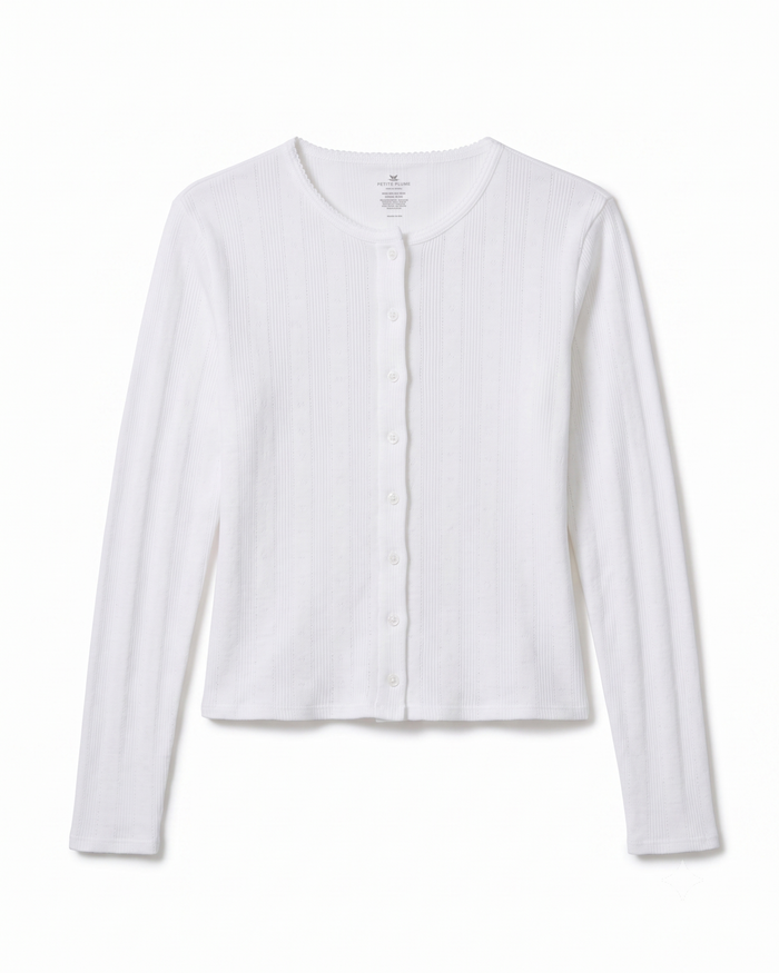 The Women’s Pointelle Cardigan in White, featuring long sleeves, a ribbed texture, a round neckline, and button-down front, is laid flat on a white background.