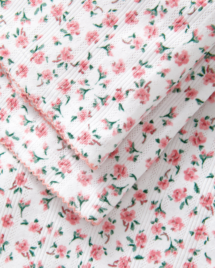 A woman stands barefoot against a plain background, wearing the Women's Pointelle Pant in Pink Floral.