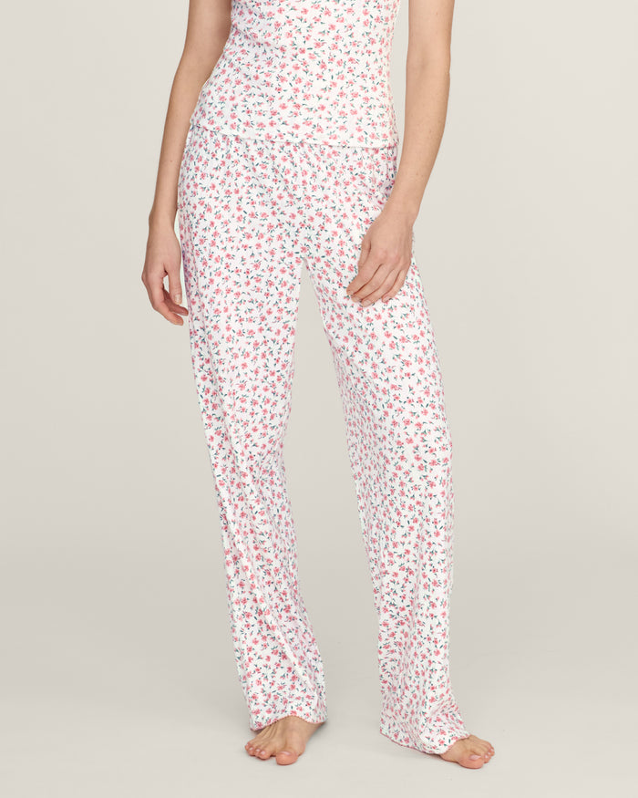 A woman stands barefoot against a plain background, wearing the Women's Pointelle Pant in Pink Floral.