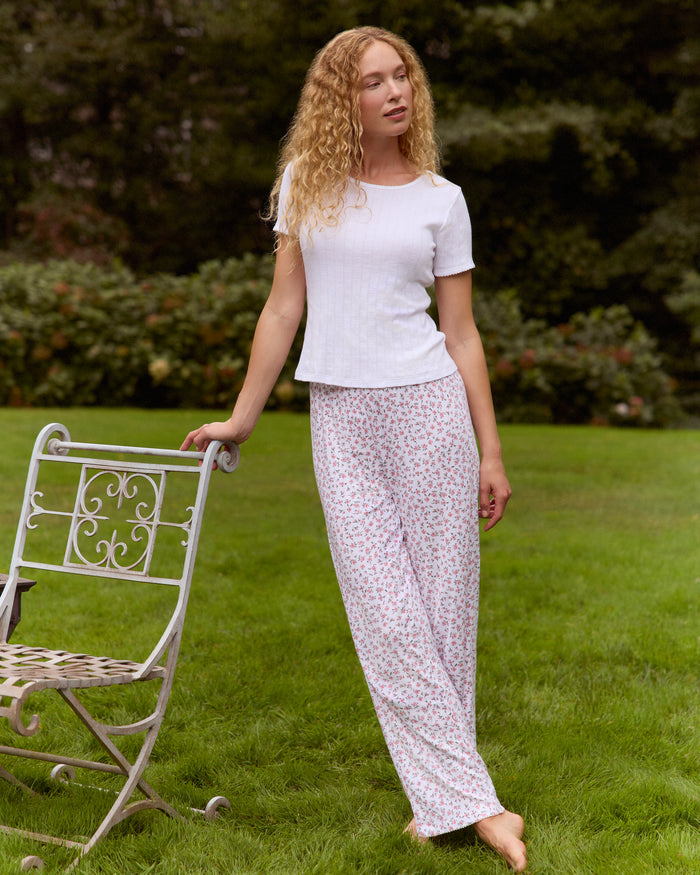 A woman stands barefoot against a plain background, wearing the Women's Pointelle Pant in Pink Floral.