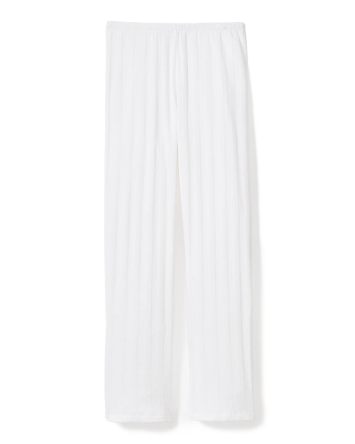 A woman stands barefoot on a light background wearing the Women's Pointelle Pant in White, paired with a sleeveless white tank top, posing with a relaxed and neutral expression.