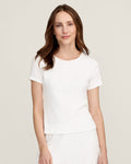 A woman with long brown hair wears the Women's Pointelle T-Shirt in White, standing against a plain light background and smiling gently at the camera.