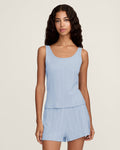 A woman with long wavy hair wears the Women's Pointelle Tank in Periwinkle, standing against a plain off-white background.
